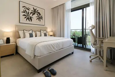 a bedroom with a large bed and a balcony at Stylish 4BD Villa Opposite Pool & Park in Dubai