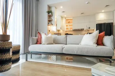 a living room with a couch and a kitchen at Stylish 4BD Villa Opposite Pool & Park in Dubai