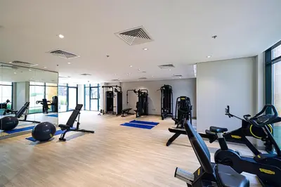 a gym with several treadmills and exercise bikes at Studio in Azizi Riviera in Dubai
