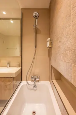 a bathroom with a tub with a shower and a sink at Upscale 2BR with Burj Khalifa Views in Dubai