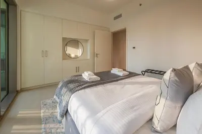 a bedroom with a large bed and a mirror at Upscale 2BR with Burj Khalifa Views in Dubai