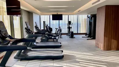 a gym with cardio equipment in a hotel room at Stylish 1BR Retreat in Sobha Crest with Balcony in Dubai