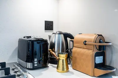 a kitchen counter with a coffee maker and a toaster at Stylish 1BR Retreat in Sobha Crest with Balcony in Dubai