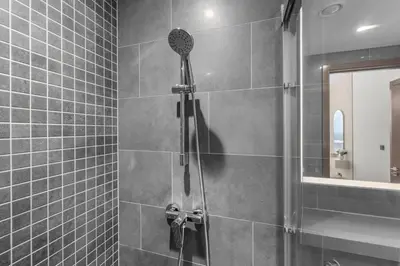 a shower with a shower head in a bathroom at Stylish 1BR Retreat in Sobha Crest with Balcony in Dubai
