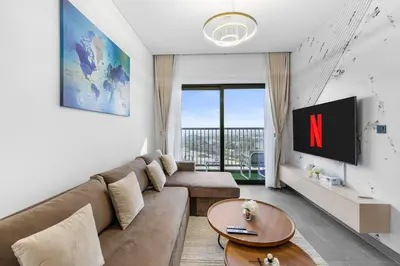 a living room with a couch and a tv at Stylish 1BR Retreat in Sobha Crest with Balcony in Dubai
