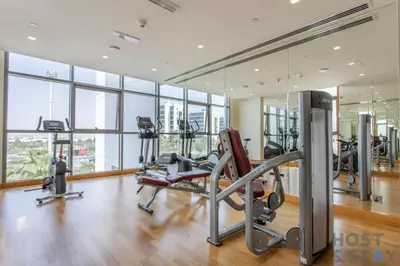 a gym with treadmills and ellipticals in a building at Parkview 2BR in Orchid, Damac Hills in Dubai