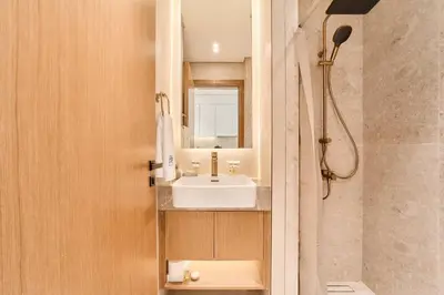 a bathroom with a sink and a shower at FAM Living Stylish Studio Apartment in Binghatti Azure JVC in Dubai