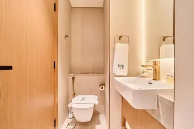 a small bathroom with a toilet and a sink at FAM Living Stylish Studio Apartment in Binghatti Azure JVC in Dubai