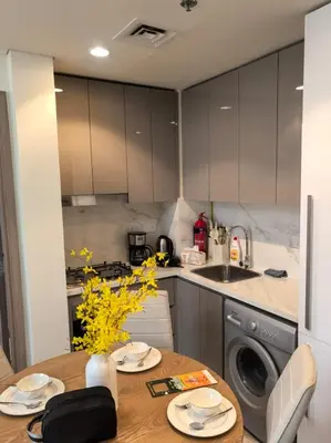 a kitchen with a table and a sink and a dishwasher at Stylish 2B escape in Dubai