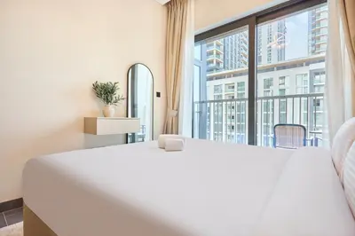 a large white bed in a room with a large window at STAY BY LATINEM Luxury 2BR Holiday Home CC 911 Near Burj Khalifa in Dubai