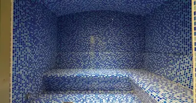 a corner of a blue tiled room with a bench at Savis Homes - Stylish 1 BR near Metro Station in Business Bay in Dubai