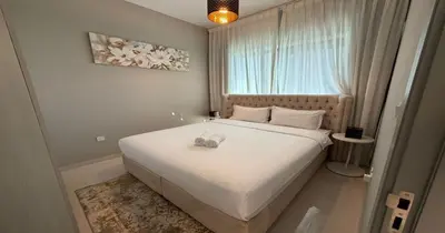 a bedroom with a large white bed with a window at Savis Homes - Stylish 1 BR near Metro Station in Business Bay in Dubai