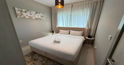 a bedroom with a bed with two shoes on it at Savis Homes - Stylish 1 BR near Metro Station in Business Bay in Dubai