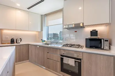 a kitchen with a microwave and a stove top oven at High-Floor Seaview 2BR with Dubai Water Canal Panorama, Steps from Metro and Marina Beach, LIV Marina, Dubai Marina by Deluxe Holiday Homes in Dubai