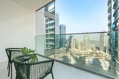 a balcony with two chairs and a view of the city at High-Floor Seaview 2BR with Dubai Water Canal Panorama, Steps from Metro and Marina Beach, LIV Marina, Dubai Marina by Deluxe Holiday Homes in Dubai