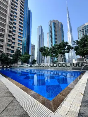 a large blue swimming pool in the middle of a city at Luxury Apartment near Dubai Mall & Burj Khalifa at Emaar 29 Boulevard by Simply Comfort in Dubai