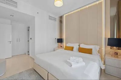 a bedroom with a white bed with two towels on it at Luxury Apartment near Dubai Mall & Burj Khalifa at Emaar 29 Boulevard by Simply Comfort in Dubai