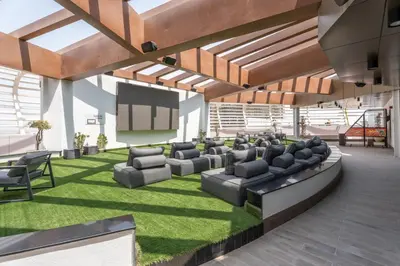 a large living room with couches and a screen at GuestReady - 1 BHK | 5min to Butterfly Garden in Dubai