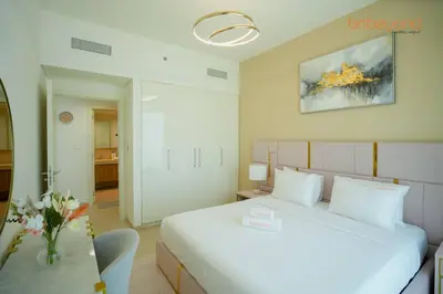 a bedroom with a large white bed and a table at Bnbeyond Skyline Luxury in Dubai