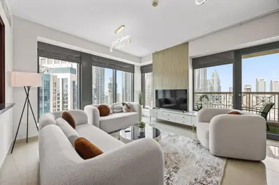 a living room with white furniture and large windows at Breathtaking Burj Khalifa & Fountain Views! in Dubai