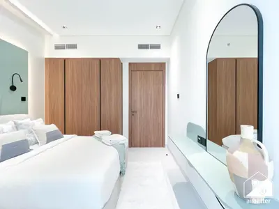 a bedroom with a bed and a large mirror at Exclusive 1BR, Modern Comfort & Prime Location in Dubai