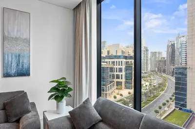 a living room with a couch and a large window at Trillionaire Residences By Binghatti - Classy 2BR in Dubai