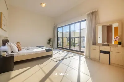 a bedroom with a bed and a large window at 4BR Villa in Prime Location with Private Garden in Dubai
