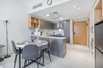 a kitchen with a table and chairs in a kitchen at Modern 1BHK Apartment in Pantheon JVC by Czechin in Dubai