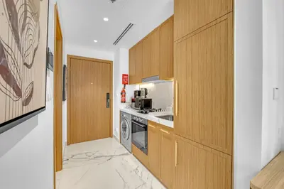 a kitchen with wooden cabinets and a stove at Elegant Studio Retreat in the Heart of Dubai in Dubai