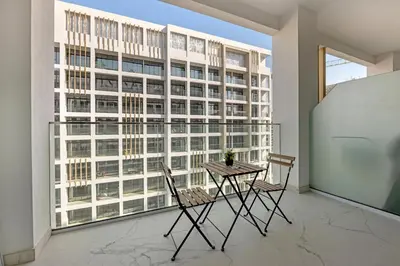 a table and chairs in a room with a large window at Elegant Studio Retreat in the Heart of Dubai in Dubai