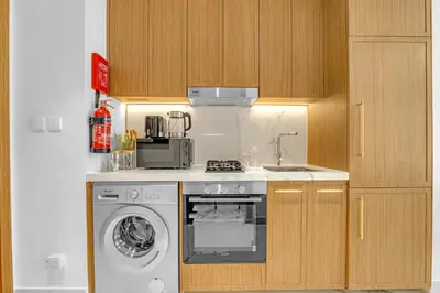 a kitchen with a stove and a washing machine at Elegant Studio Retreat in the Heart of Dubai in Dubai