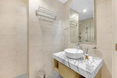 a white bathroom with a sink and a shower at Elegant 1 Bedroom Retreat in Business Bay in Dubai