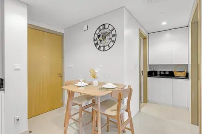a dining room with a table and chairs and a clock at Elegant 1 Bedroom Retreat in Business Bay in Dubai