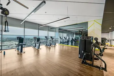 an empty gym with treadmills and elliptical machines at Elegant 1 Bedroom Retreat in Business Bay in Dubai