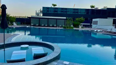 a large swimming pool in front of a building at Elegant 1BR with Bedroom Balcony - Sobha Crest C in Dubai