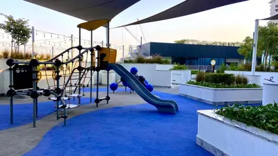 a playground with a slide on a blue carpet at Elegant 1BR with Bedroom Balcony - Sobha Crest C in Dubai