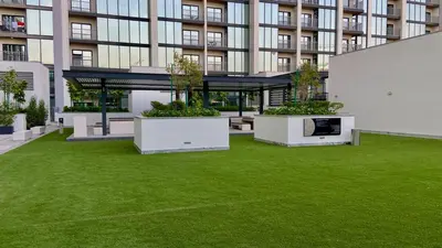 a large building with a lawn in front of it at Elegant 1BR with Bedroom Balcony - Sobha Crest C in Dubai