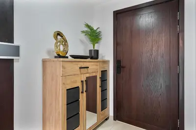 a wooden cabinet with a plant on it next to a door at GlobalStay The Residences Tower 1 Apartments Downtown Dubai in Dubai