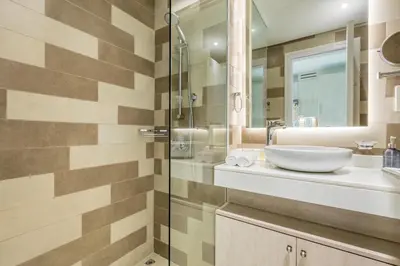 a bathroom with a sink and a glass shower at Upgraded LUX Infinity Pool with Beach Access in Dubai