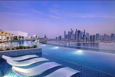 a hotel swimming pool with a view of the city at Upgraded LUX Infinity Pool with Beach Access in Dubai