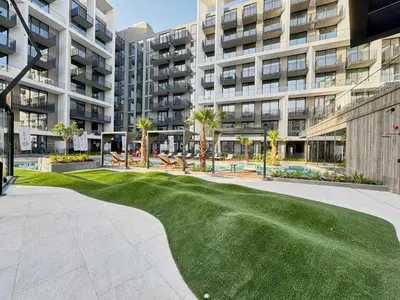 a golf course in front of a large apartment building at Elegant Apartment near Miracle Garden with Pool & Gym Access in Dubai