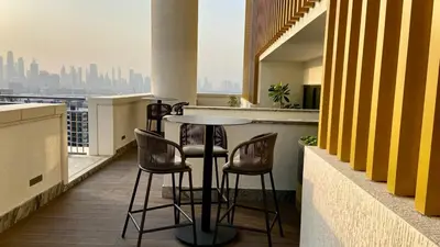 a table and chairs on a balcony with a view at Bright, Breezy and Central 1BR with Extra Room in Dubai