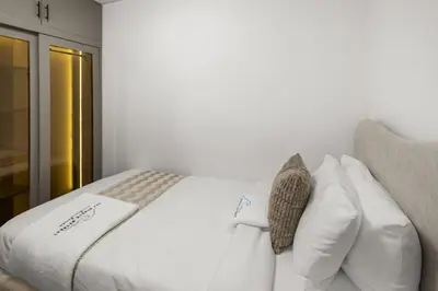 a white bed with white pillows on top of it at Bright, Breezy and Central 1BR with Extra Room in Dubai