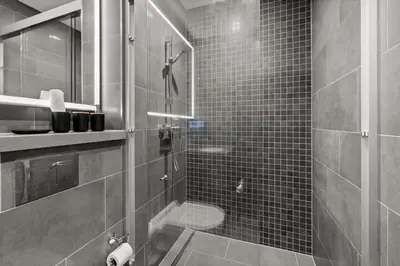 a bathroom with a shower with a glass door at Bright, Breezy and Central 1BR with Extra Room in Dubai
