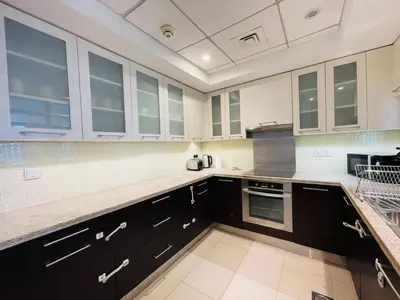 a large kitchen with black cabinets and white appliances at 2BR apartment in the Heart of Downtown Dubai with Burj Khalifa View by Norbu Holiday Homes in Dubai