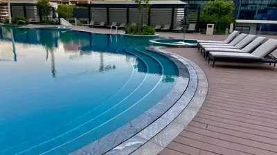 a swimming pool with two lounge chairs next to it at Premium Stay in Sobha 1BR with Extra Room and Balcony in Dubai