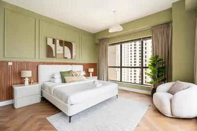 a bedroom with a white bed and a chair at GuestReady - 2BR | JBR Beach Stay | Canal View in Dubai