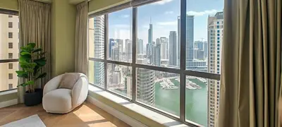 a room with a large window with a chair and a view at GuestReady - 2BR | JBR Beach Stay | Canal View in Dubai