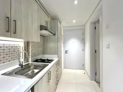 a white kitchen with a sink and a stove at LUX Infinity Pool with GYM, Private Beach Studio in Dubai