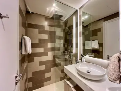 a white bathroom with a sink and a mirror at LUX Infinity Pool, Gym, Beach, Parking Studio in Dubai